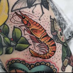 a close up of a person's arm with tattoos on it and an insect in the background