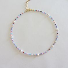 Colorful beaded choker necklace, Freshwater pearl necklace, 18k gold necklace, Rainbow seed bead necklace for women I offer two versions of an iridescent necklace with freshwater pearls, with gold beads, with a clasp and chain extension made of brass with 18k gold plating. Second version of the necklace with silver beads and stainless steel clasp. Measure the length of your neck with a measuring tape or you can use any string, rope or phone cable, and afterward apply the measurements on a regula Dainty Pearl Necklace With Colorful Beads, Colorful Pearl Beaded Choker Necklace, Pearl Choker With Colorful Round Beads, Pearl Choker With Colorful Beads For Gifts, Dainty Pearl Necklaces With Colorful Beads, Colorful Beads Pearl Choker Necklace, Colorful Beaded Pearl Choker Necklace, Dainty Pearl Beaded Necklaces With Tiny Beads, Pearl Choker With Tiny Beads