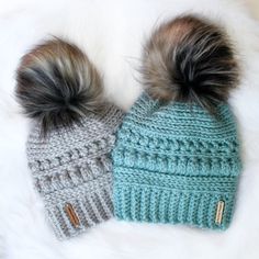 two knitted hats with pom - poms on top