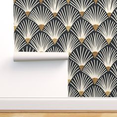 an art deco wallpaper with black and gold fan pattern on it, next to a white door