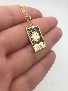 Elevate your style with our exquisite Sun Tarot Card Necklace, a captivating piece crafted in radiant 14K gold. The celestial charm of this necklace is accentuated by a delicately engraved rectangular pendant, making a bold statement in the realm of spiritual jewelry. This unique accessory not only serves as a fashionable adornment but also holds profound symbolic significance. Embrace the celestial energy and channel the sun's vibrant power with this stunning piece, making it an ideal gift for Celestial Energy, Sun Tarot Card, Tarot Card Necklace, The Sun Tarot Card, The Sun Tarot, Winter Necklace, Spiritual Necklace, Card Necklace, Pendant Making