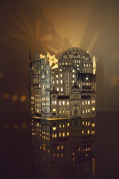 a paper model of a city at night with lights shining on the buildings and windows