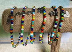 "These are six multi colored beaded anklets/bracelets.  They consist of small multi colored seed beads, silver plated charm and spacer and heavy duty stretch jewelry cord.  Charms include:  Winged heart, Moon, \"Joy\", Fish, Flower and Butterfly.   A 10\" anklet fits average to large ankles.  I can make smaller or larger ones upon request. Measure your ankle or wrist and add 1/4\".  Great colorful anklets.  Ideal shower favor thank you gifts.   The bracelet is shipped in sheer fabric gift bags.  Ideal for gift giving. I take pride in my work, and customer satisfaction is very important to me.  If you have any questions or requests, please contact feel free to contact me." Colorful Anklets, Ankle Bracelets Boho, Heart Moon, Winged Heart, Anklets Boho, Rainbow Bracelet, Beaded Anklets, Ankle Bracelet, Anklet Bracelet