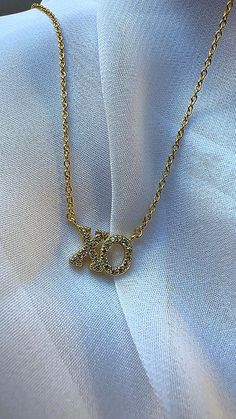 Show your love in style with our stunning 14K Gold-Plated XO Necklace, adorned with sparkling Cubic Zirconia. This trendy, yet timeless piece features an "XO" design that symbolizes hugs and kisses, making it a perfect gift for someone special or a chic accessory to elevate your own look. The Cubic Zirconia stones add just the right amount of sparkle, creating an eye-catching shine without breaking the bank. Crafted with high-quality 14K gold plating, this necklace ensures long-lasting wear and a luxurious feel at an affordable price. It's versatile enough to wear every day or layer with your other favorite pieces for a fashionable statement. Features: *Material: 14K Gold Plated *Stone: Brilliant Cubic Zirconia *Chain Length: Adjustable for the perfect fit  *Lightweight and comfortable for Xo Necklace, Xo Design, Astoria Ny, Hugs Kisses, Necklace Love, Love Jewelry, Dope Jewelry, Hugs And Kisses, Necklace Dainty