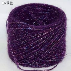 purple yarn is spooled on a white surface