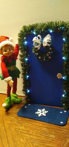 an elf is standing next to a christmas door