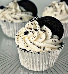 two cupcakes with white frosting and black sprinkles