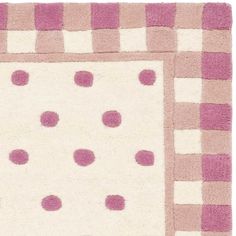 a pink and white rug with polka dots on it