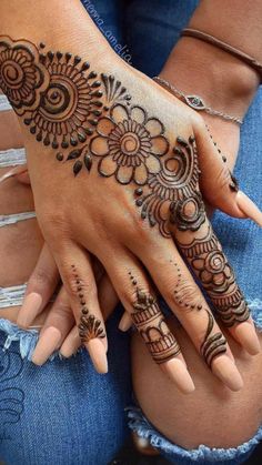 a woman's hand with henna tattoos on it