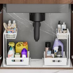 two white bins with cleaning products in them on a counter top under a faucet