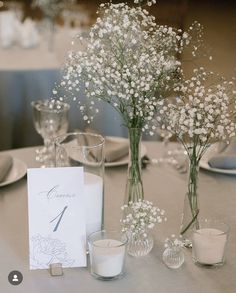 the table is set with flowers, candles and place cards for guests to sit at