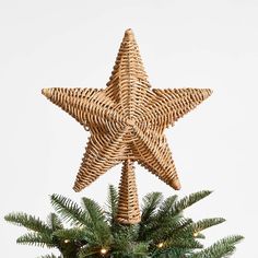 a wicker star ornament on top of a christmas tree