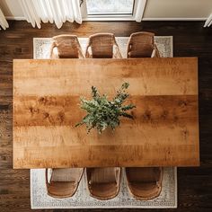 an overhead view of a wooden table with chairs and a potted plant on it