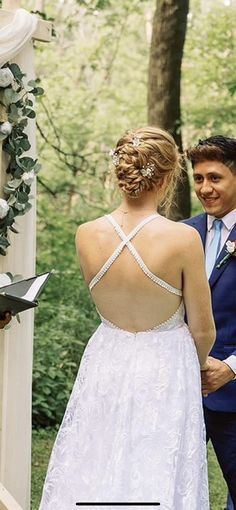 a man and woman standing next to each other in front of a wedding ceremony arch