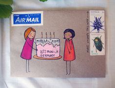 an envelope with a drawing of two women holding a birthday cake on top of it