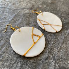 "These gorgeous porcelain earrings are inspired by Kintsugi - a Japanese technique of restoration ceramics. However they have never been broken and glued together, they are one piece. They are made of snow-white fine bone china porcelain and gold veins are glided with genuine gold. Every pair is different, unique and there are no two identical pieces. This means that the product that you receive is slightly different than in the photo. The diameter is approx. 50mm/2\". Hooks are made of stainles White Round Pendant Earrings For Gifts, White Round Pendant Earrings As A Gift, Handmade White Circular Earrings, White Handmade Circular Earrings, Porcelain Clay Jewelry, Kintsugi Earrings, Porcelain Jewellery, Gold Veins, Beach Jewelry Boho