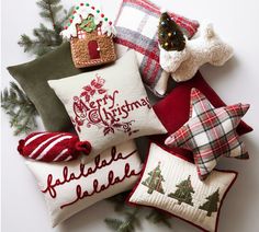 christmas pillows and other decorative items are arranged on a white surface