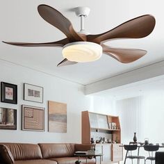 a living room with a brown couch and ceiling fan