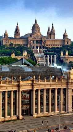 an old building in the middle of a city with many spires on it's roof