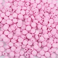 pink beads with white letters on them