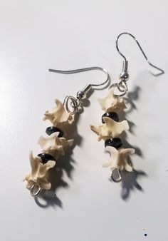 These spooky earrings are made from real rattlesnake vertebrae bones, and real hematite stone. Bones may have a natural patina. Hand set and finished, each piece is unique and perfect for your next spooky event, or just a conversation piece for daily wear. As these are real bones, they are small and delicate, so store and handle with care! Earrings are finished on a hypoallergenic ear wire. Bones were purchased from BackWoodBones on Etsy! Matching necklace available. Know your local state and co Diy Bone Jewelry, Animal Bone Jewelry, Bone Accessories, Spooky Earrings, Bead Drop Earrings, Weird Jewelry, Bone Crafts, Vulture Culture, Bone Earrings