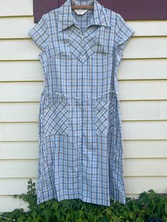 Super cute 1980's Sears zip front light weight dress in blue and yellow plaid on woven cotton-poly. Original belt included. This gives major 90's vintage girl vibes. Two front pockets. Made in the USA. Good vintage condition, some stitching in the left shoulder back seam is loose. Falls below the knee on most.  Measured flat: Shoulder: 15" Chest: 20" Waist: 19" Hip: 22" Length: 44" Best fit: Femme Medium to Large. Please measure against yourself for best fit. Retro Cotton Plaid Dress For Picnic, Retro Gingham Plaid Cotton Dress, Retro Plaid Dress For Daywear, Casual Blue Plaid Dress For Daywear, Casual Plaid Dress For School, Vintage Cotton Plaid Dress, Vintage Short Sleeve Plaid Cotton Dress, Vintage Short Sleeve Plaid Dress For Spring, Vintage Plaid Short Sleeve Dress For Spring