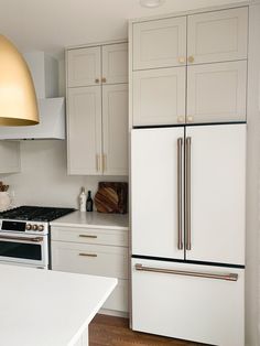 a kitchen with white cabinets and gold accents