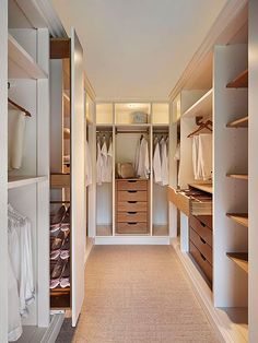 an empty walk in closet with lots of drawers