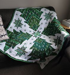 a green and white christmas tree quilt on a couch