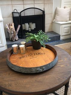 a table with a potted plant and two glasses on it in front of a fireplace