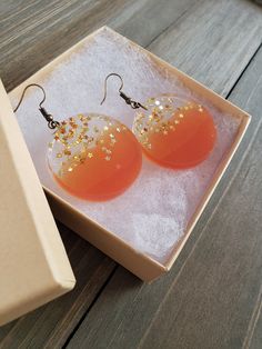 Beautiful and fiery sunset orange resin disk earrings, filled with gold stars. Vibrantly orange circle half circles, paired its clear stary other half, perfectly preserved in resin for it's natural beauty. Vividly colorful, lightweight, and dazzling stars in every light setting ♥ Be sure to check out the ORANGE EARRINGS section at EarringsbyLCreations for all beautiful orange colored earrings available! https://www.etsy.com/shop/EarringsByLCreations?section_id=28420987 Made with quality material Orange Resin Dangle Earrings, Orange Dangle Resin Earrings, Orange Resin Jewelry For Party, Party Orange Earrings With Ear Wire, Nickel Free Orange Earrings For Party, Nickel-free Orange Earrings For Party, Hypoallergenic Round Orange Earrings, Orange Hypoallergenic Round Earrings, Orange Resin Earrings