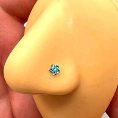 a close up of a person's hand holding a yellow plastic object with a blue flower on it