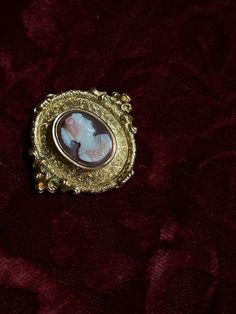 An adornment worthy of a museum! This stunning 19th century Sardonyx Cameo is a testament to Napoleon era French jewelry design. Crafted circa 1850-1860 in 18 carat gold, this brooch features a vibrant cameo of a aristocratic woman, set again a delicate peachy-hued sardonyx mount. The 18-carat gold mounting is also exceptional, with a gilded design brimming with fine detailing, and scrolling foliate motifs. The silhouette it creates makes it feel as if it should be hung in the halls of a palace! Elegant Yellow Gold Baroque Brooches, Luxury Oval Cabochon Brooches, Antique Yellow Gold Brooches With Intricate Design, Yellow Gold Baroque Brooch For Formal Occasions, Antique Gold Jewelry For Opera, Formal Yellow Gold Baroque Brooches, Luxury Gold Brooches With Cabochon, Elegant Baroque Brooches For Formal Occasions, Vintage Yellow Gold Baroque Brooch