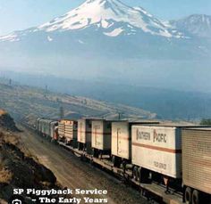 a train traveling down tracks next to a snow - capped mountain in the background with text overlay that reads, sp piggyback service the early years