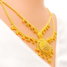 This 22k gold long necklace set features an ornamental tasseled drop design, perfect for adding elegance to any outfit. Weighing 53.9 grams, it showcases a yellow gold finish that enhances its intricate and eye-catching appearance. The set has a length of 24 inches with a 2.25-inch drop and includes adjustable 1.5-inch links for a comfortable fit. Secured with a hook lock, it combines style and practicality. The matching earrings, each 1.75 inches long, feature screw back posts for added security. Ideal for those who appreciate luxurious and sophisticated jewelry, this set brings a touch of opulence and tasseled charm to your collection. PRODUCT DETAILS Gold Purity(karat): 22k Gold Weight(grams): 53.9 Item Finish: Yellow Gold Set Length: 24" Drop Length: 2.25" Adjustable Links: 1.5" Links Gold Long Temple Necklace With Intricate Design, Gold Temple Necklace With Intricate Design, Elegant Yellow Gold Bridal Necklace With Latkans, Yellow Gold Plated Chandbali Necklace, Elegant Gold Temple Necklace With Latkans, Elegant Gold Plated Bridal Necklace With Latkans, Elegant Bridal Necklace With Latkans In Gold Plated, Traditional Yellow Gold Long Temple Necklace, Traditional Long Yellow Gold Temple Necklace