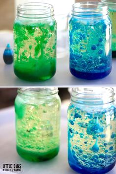 four jars filled with different colored liquids on top of a table next to each other