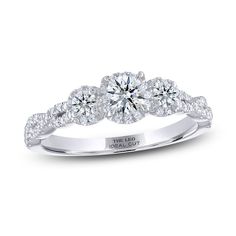 a three stone engagement ring with round diamonds on the shoulders and side stones set in 18k white gold