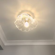 a ceiling light that is on in the middle of a room with white walls and ceilings