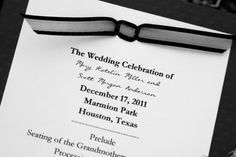 the wedding program is being held in black and white with a ribbon on it's front