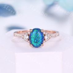 a blue opal and diamond ring sitting on top of a white box