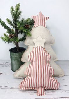 a small christmas tree sitting next to a potted plant on top of a wooden table