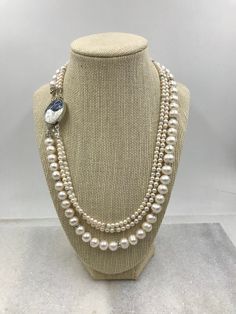 Wow..If you are looking for a statement necklace, here you go. This triple strand pearl necklace is made of luminous freshwater pearls ranging in size from petite 4mm to 5mm up to 9mm. Each strand of pearls also is highlighted by silver and cz spacers to add that little extra touch of shine. A glorious 28mm abalone box clasp set in silver finishes off the necklace. The clasp is so pretty I've pictured it on the side as opposed to the back as I wouldn't want to hide it if I was wearing it! This w Multi-strand Pearl Drop Necklace, Pearl White Multi-strand Pearl Necklace, Multi-strand Pearl White Necklace With Pearl Pendant, Multi-strand Pearl Necklace With Pearl Charm, Double Strand Akoya Pearl Necklace In Pearl White, Double Strand Pearl Embellished Jewelry, Pearl White Double Strand Akoya Pearl Necklace, Pearl White Akoya Pearl Double Strand Necklace, White Multi-strand Pearl Embellished Necklace