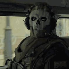 a man in a car with a skull mask and headphones is looking out the window