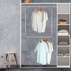 an open closet with clothes and shoes hanging on the rack, next to a stool