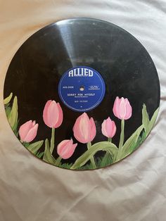 a black record with pink flowers painted on it