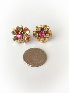 Fantastic 10k gold filled vintage earrings! Shaped like a flower. There are 6 golden petals with  5 white rhinestones around them and a large pink rhinestone center. Backings are screw on style and can be adjusted to preferred fit. Marked 1/20 10k gold filled. Overall good condition. All rhinestones are intact with mild deadening. Moderate tarnish and wear. 7/8 of an inch wide. Shop accepts PayPal,credit cards,Etsy gift cards,and postal money orders.♥Check out the rest of the shop♥https://www.et Pink Vintage Earrings For Anniversary, Vintage Flower Shaped Earrings For Anniversary, Vintage Rose Gold Flower Earrings, Vintage Pink Flower-shaped Earrings, Vintage Flower Shaped Jewelry With Rhinestones, Vintage Flower-shaped Jewelry With Rhinestones, Vintage Rose Gold Flower Earrings For Wedding, Crown Necklace, Paypal Credit Card