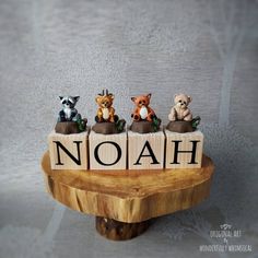 three small animals sitting on top of a wooden block with the word noah spelled out