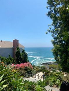 an ocean view from the top of a hill with trees and bushes in front of it