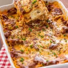 a casserole dish with meat and cheese being lifted from the casserole