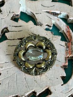 This brooch is a lovely antique one.  It is in great codnition for its age.  This brooch has a clear quartz crystal stone, with gorgeous ornate detailing all the way round it.  This brooch has a lovely size, with a diameter of approximately 3cm.  It is lovely and light weight as well.  If you love this and feel the price is a little out of reach, please pop me a message and we can sort something out. Vintage Gemstone Brooches For Formal Occasions, Antique Bronze Brooches For Collectors, Antique Bronze Collectible Brooches, Vintage Silver Brooch With Gemstone, Vintage Silver Gemstone Brooch, Vintage Bronze Brass Brooches, Victorian Brass Brooches For Formal Occasions, Victorian Brass Brooch For Formal Occasions, Vintage Brooch With Antique Finish